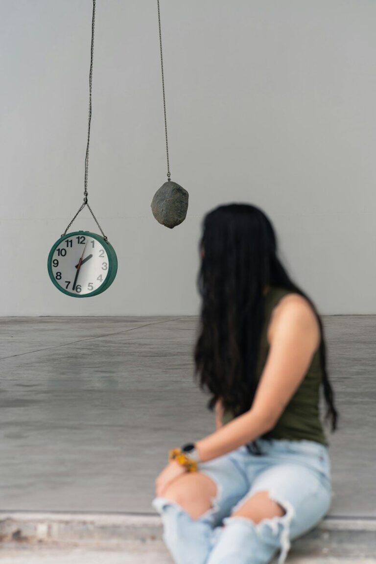 a woman sitting on the floor in front of a clock