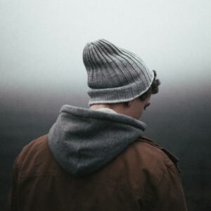 young man wearing knit cap, representing sadness