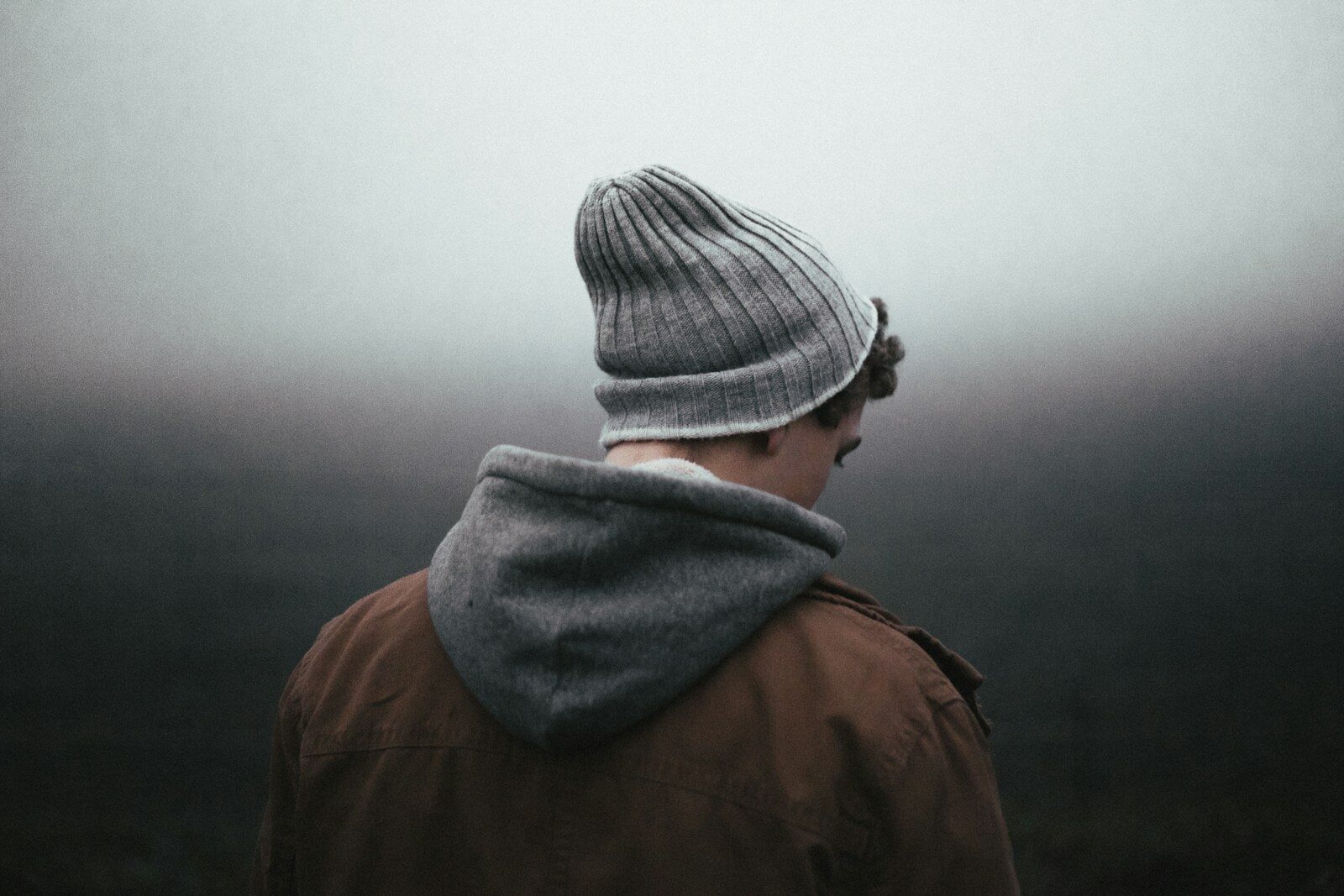 young man wearing knit cap, representing sadness