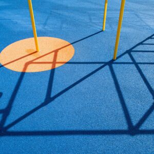 A playground with a blue ground and yellow poles
