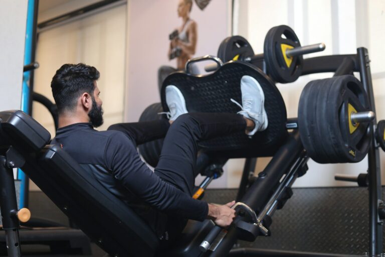 man in black long sleeve shirt sitting on a leg press exercise machine